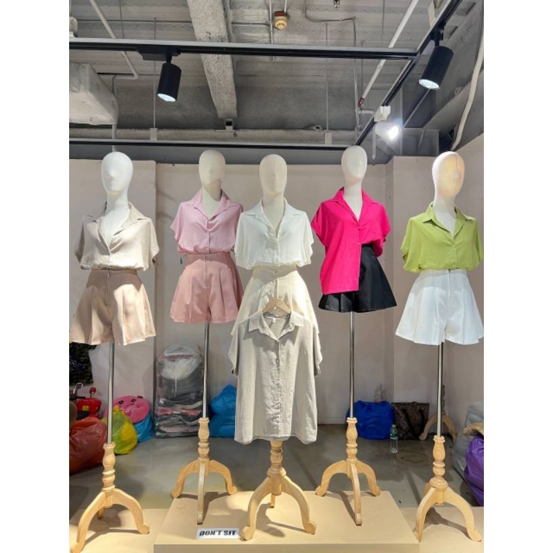 Illustration of a second-hand clothing store with clothes racks and warm lighting.